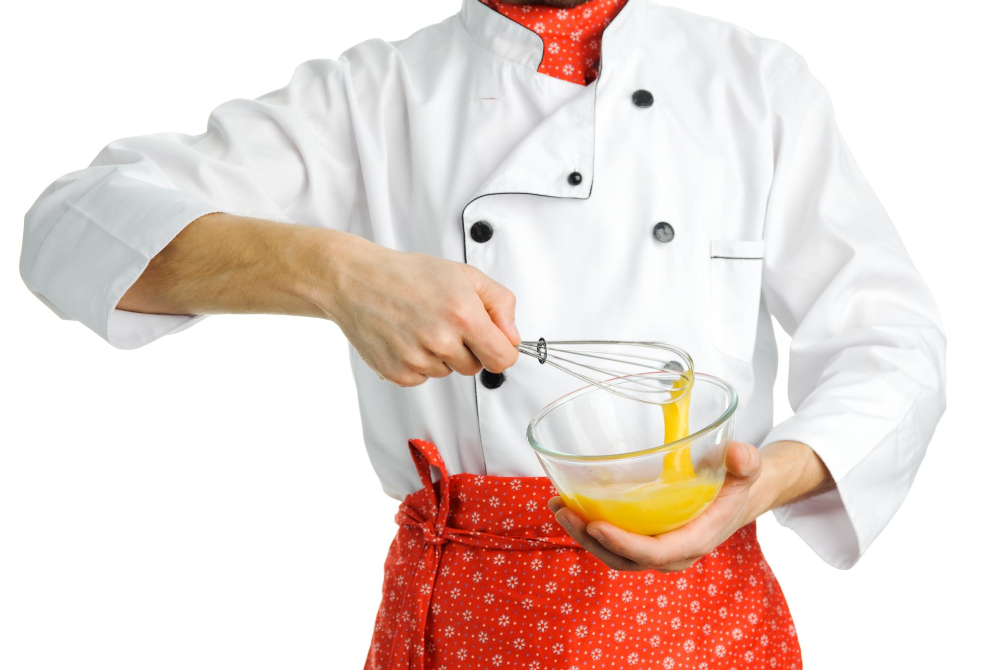 Chef in cucina professionale che prepara un sugo